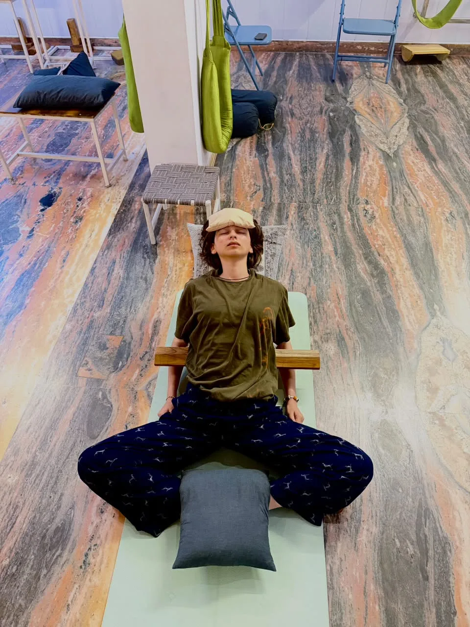 A student sitting quietly with palms together in the studio