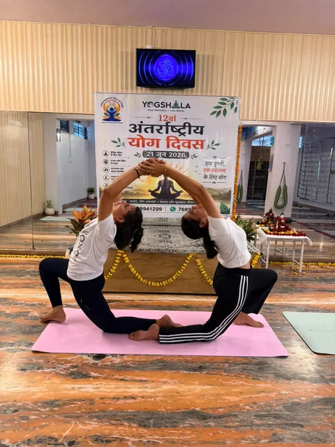 Two participants demonstrating a partner yoga pose at an event