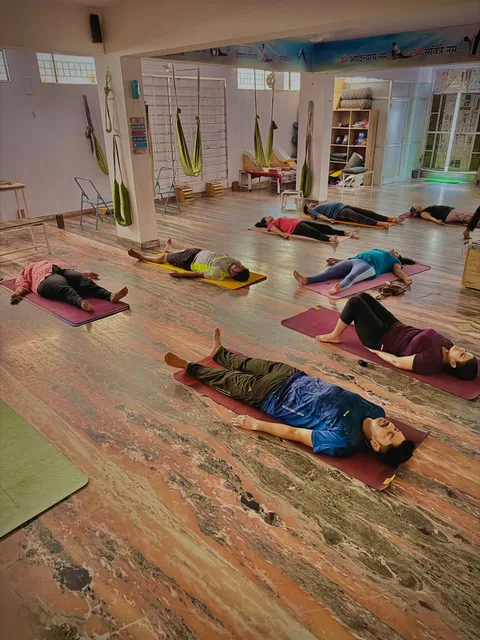 A group resting on yoga mats during a studio session