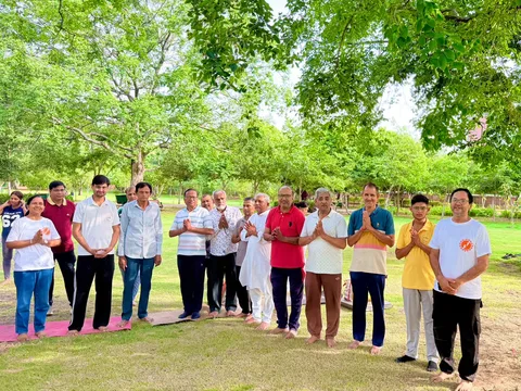 The yoga community gathered outdoors under green trees